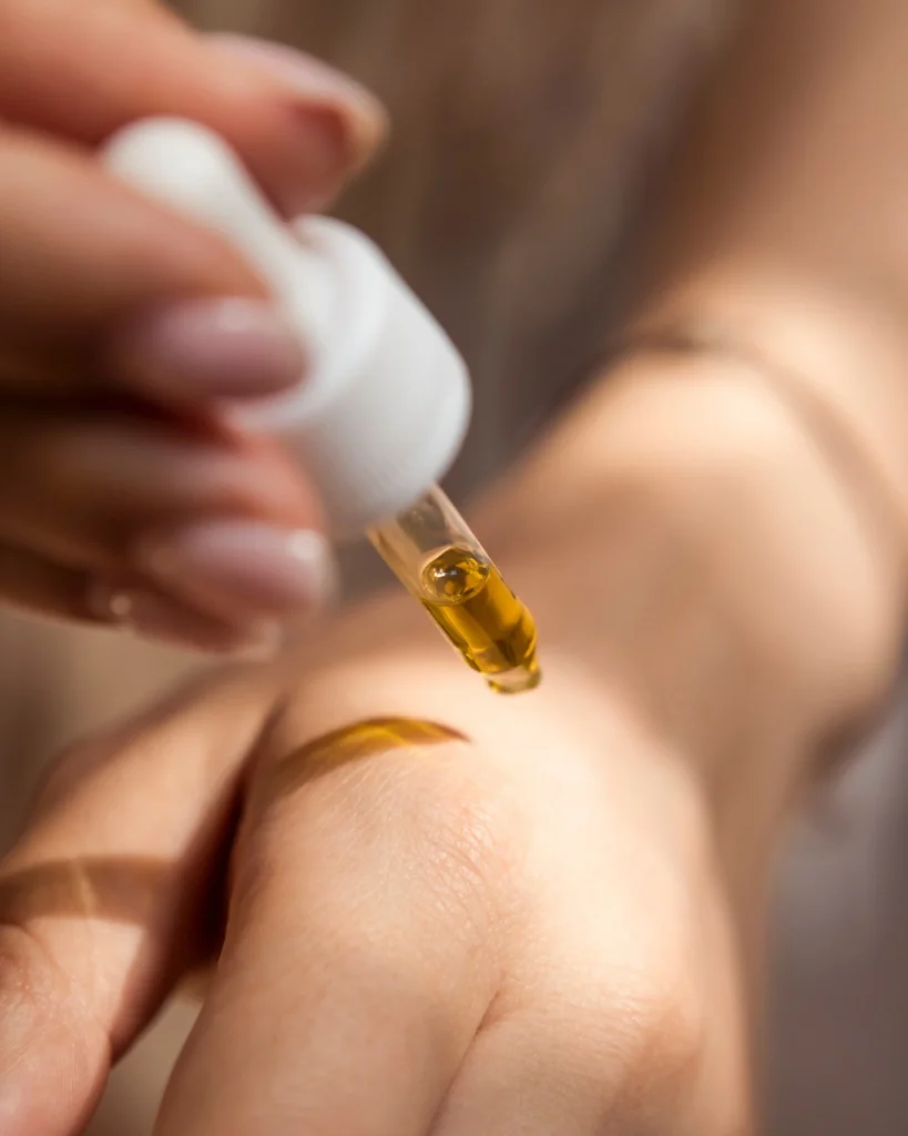 Upclose shot of a person dispensing a skincare oil from a dropper