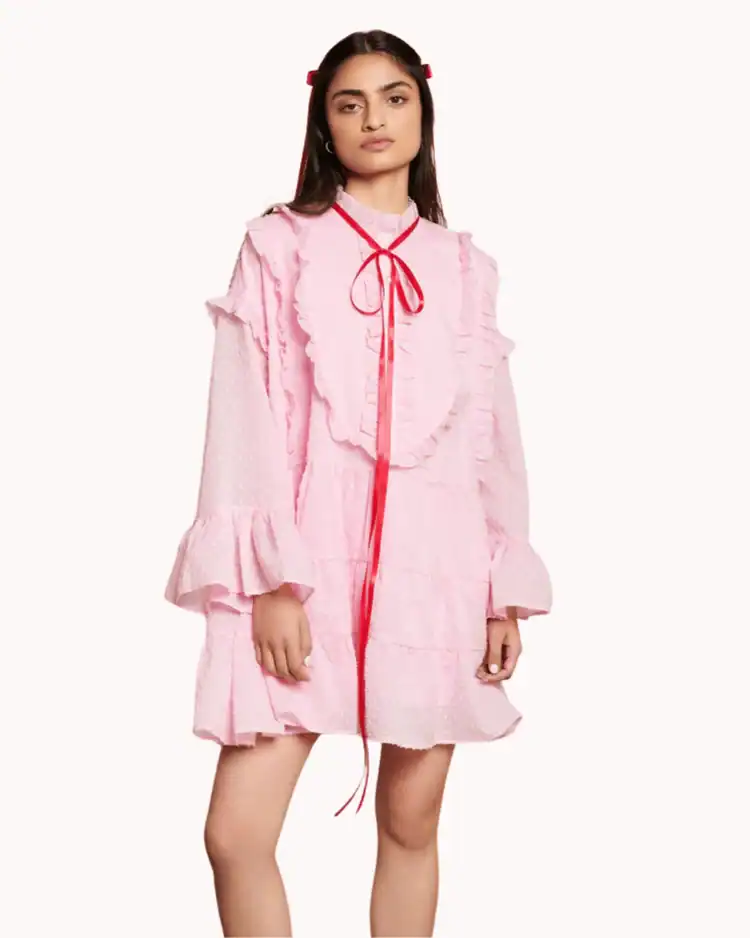 Model poses wearing pink and red Bow Mini Dress