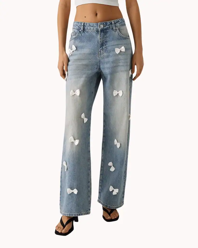 model wearing jeans with small white bows all over