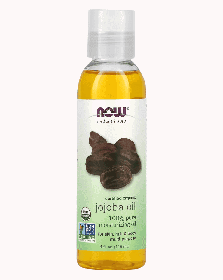 Jojoba oil bottle on a plain pastel pink background