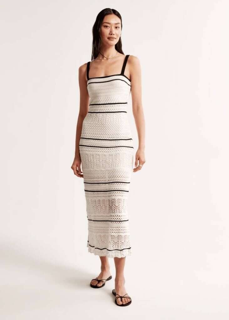 Model wearing a striped white and black crochet dress