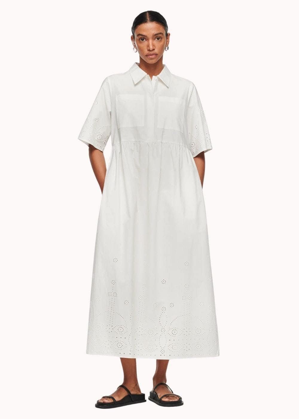 Model wearing a long white broderie dress