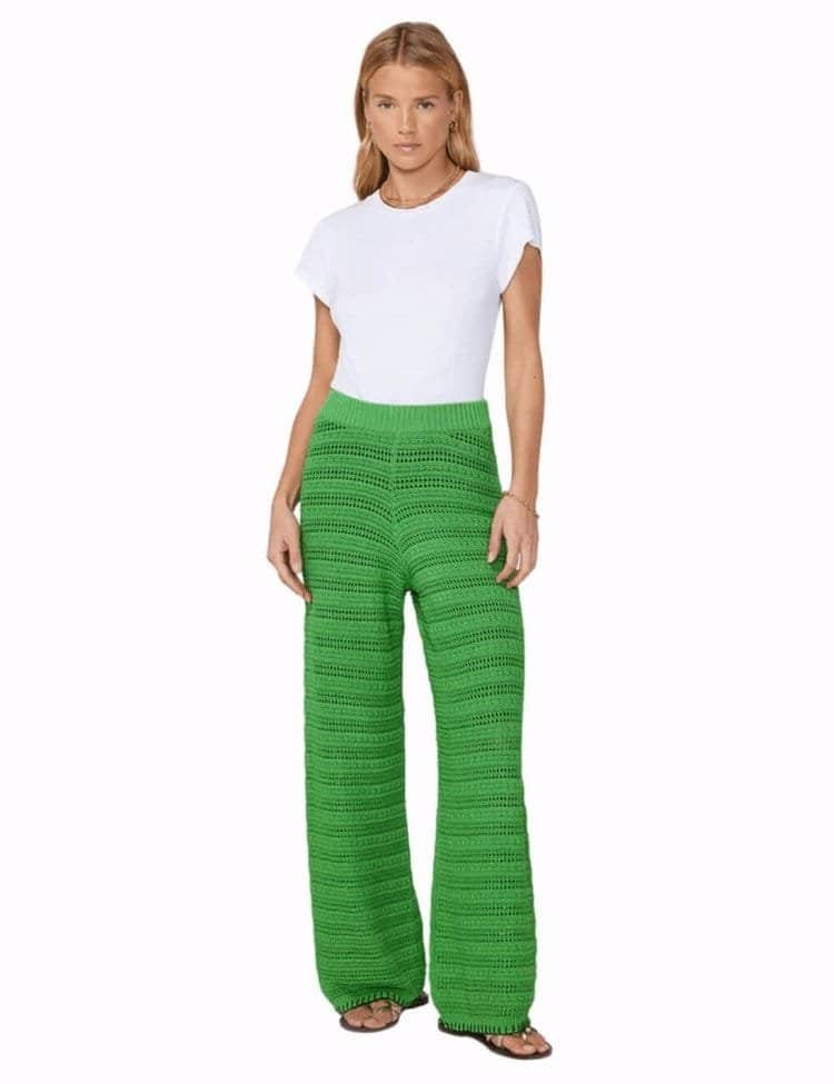 Model wearing green crochet knit trousers. 