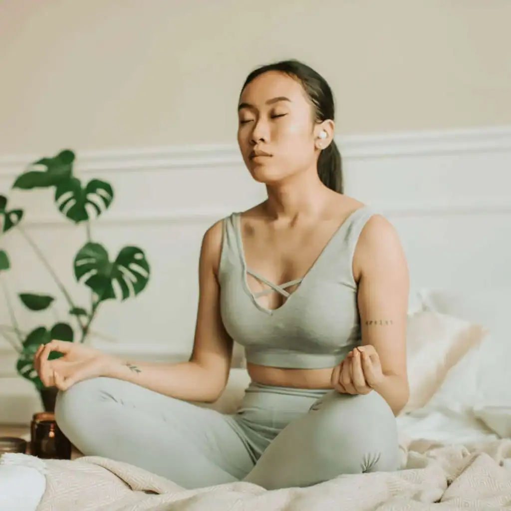 Asian-women-meditating-in-a-grey-crop-top-and-matching-leggings