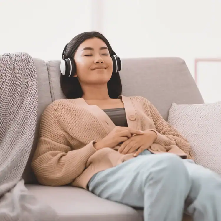 Calm-Asian-woman-listening-to-music-wearing-headphones