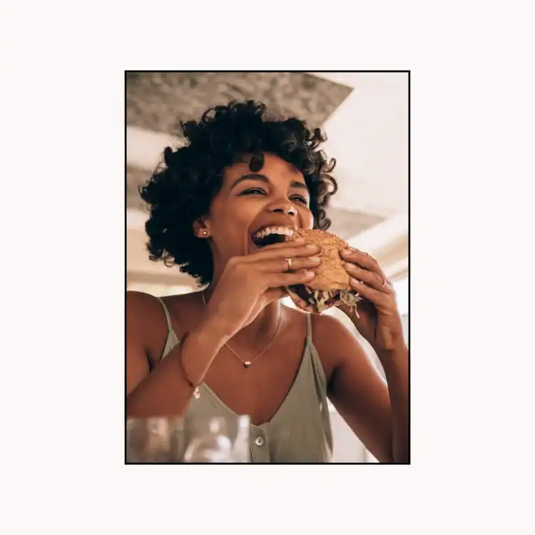 Woman-Eating-Burger-at-Restaurant.-Saturday-selfcare-ideas