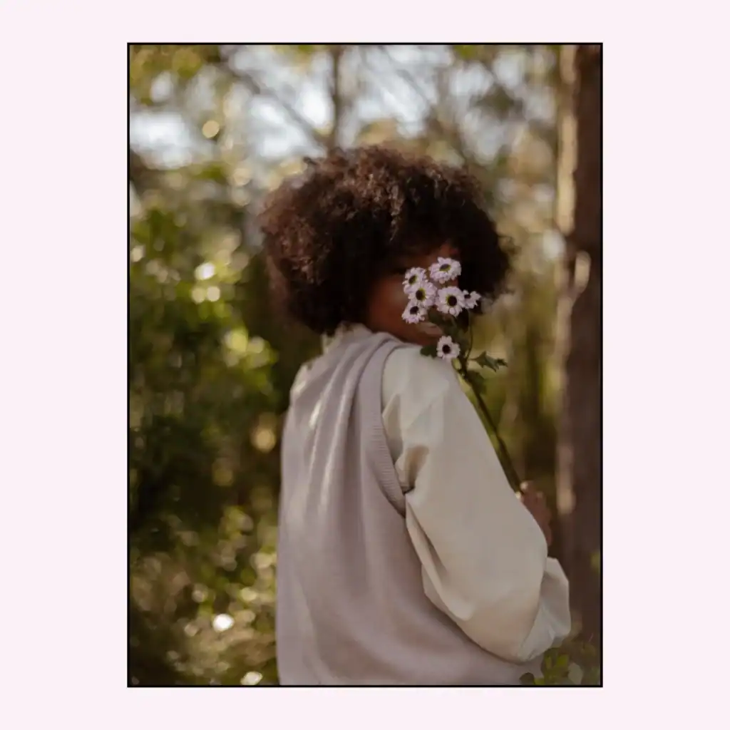 Woman-among-foliage-holding-pretty-pink-flowers-in-front-of-her-face. Morning Journal Prompts