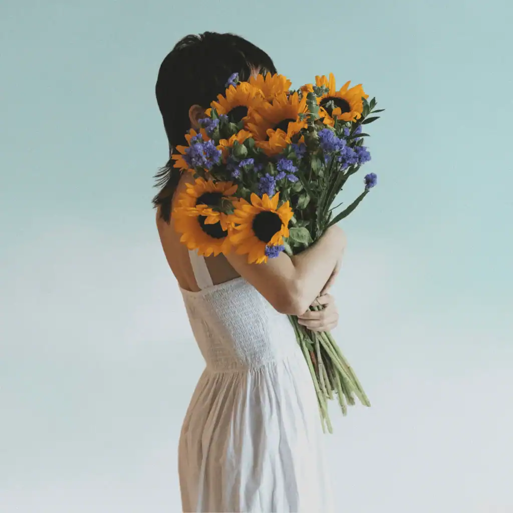 Woman-holding-a-bouquet-of-sunflowers.-100-Solo-Date-Ideas
