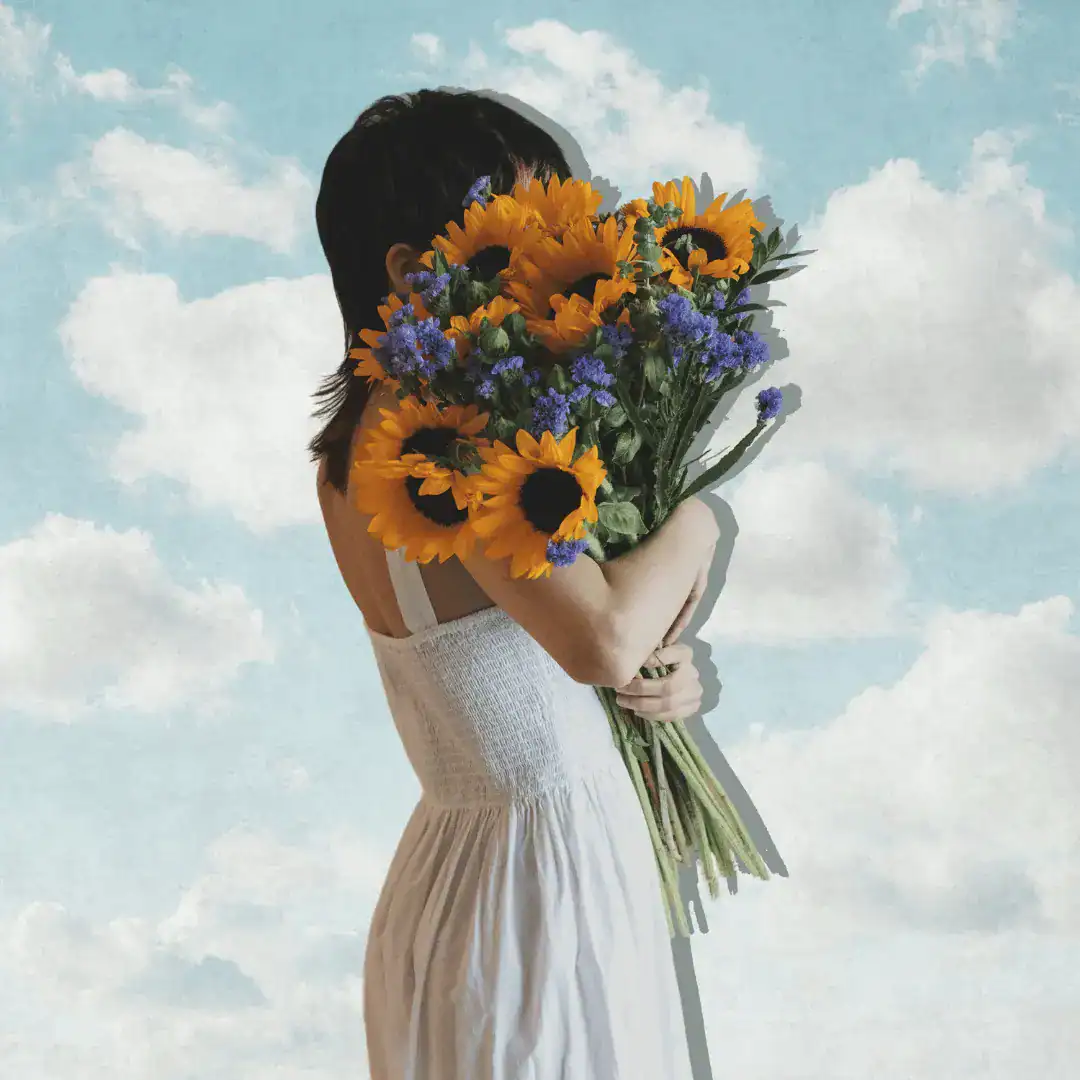 Woman-in-a-white-dress-holding-sunflowers