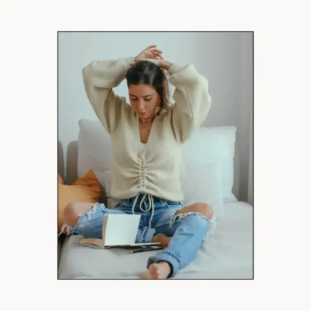 Woman-sitting-on-a-sofa-tying-her-hair.-Positivity-Instagram-captions