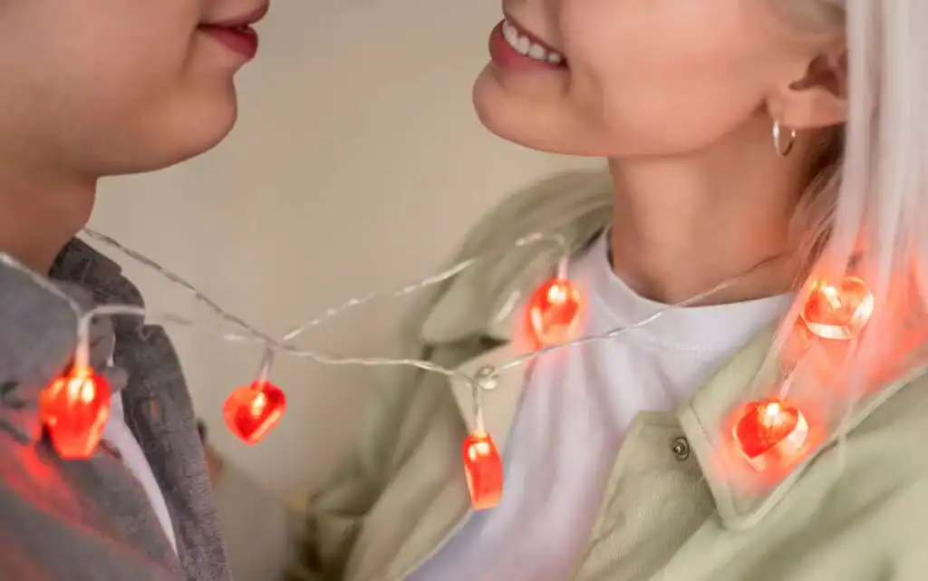 close-up-of-a-man-and-a-woman-wrapped-in-red-heart-fairy-lights.-What-is-Love-bombing-1-1024x641-1