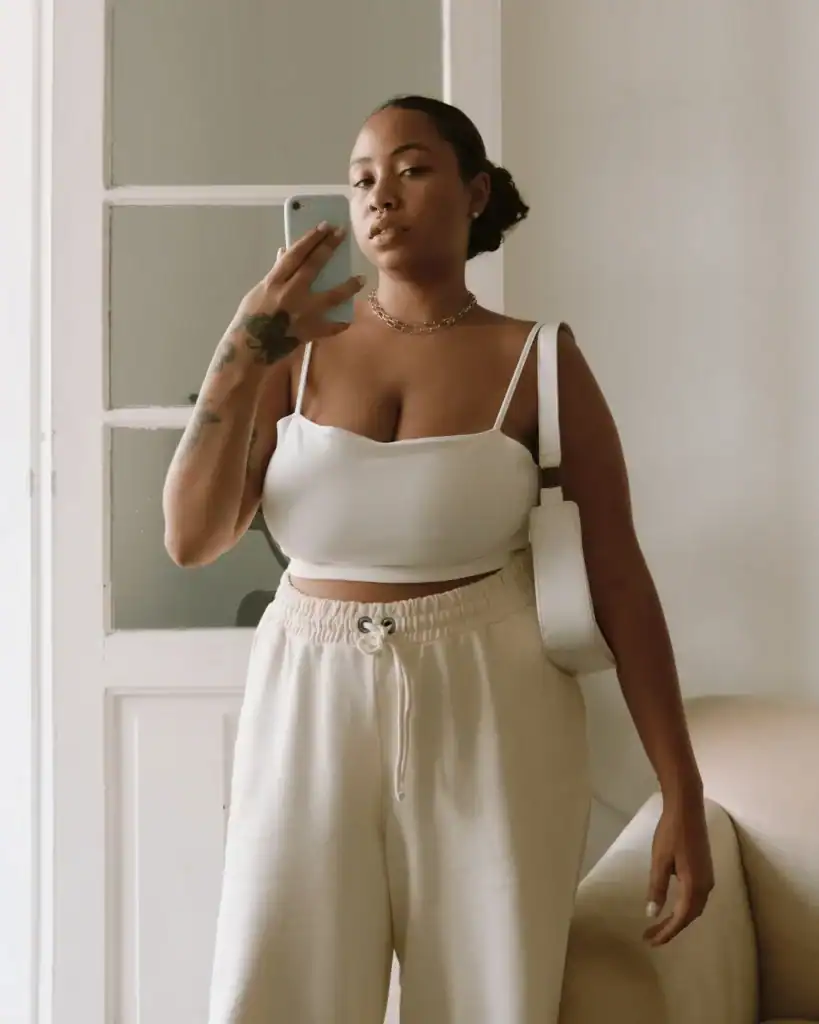 woman-with-a-neutral-white-and-cream-outfit-and-a-bag-taking-a-selfie-indoors.-Pillow-method