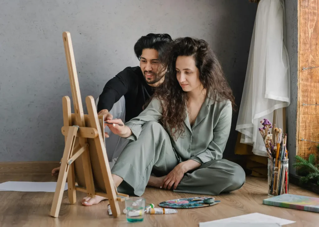 Man and Woman Sitting on the Floor While Painting. hobbies for couples